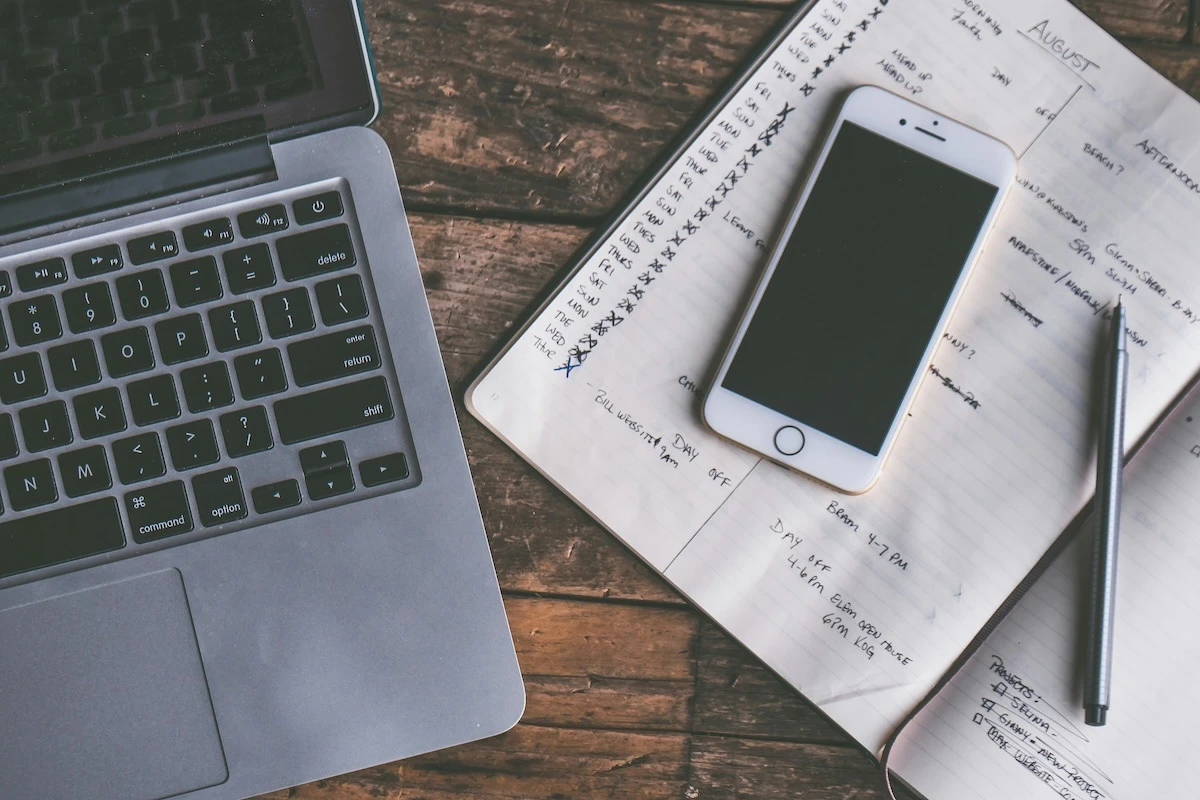 A picture of a laptop, phone and a to-do list on a desk